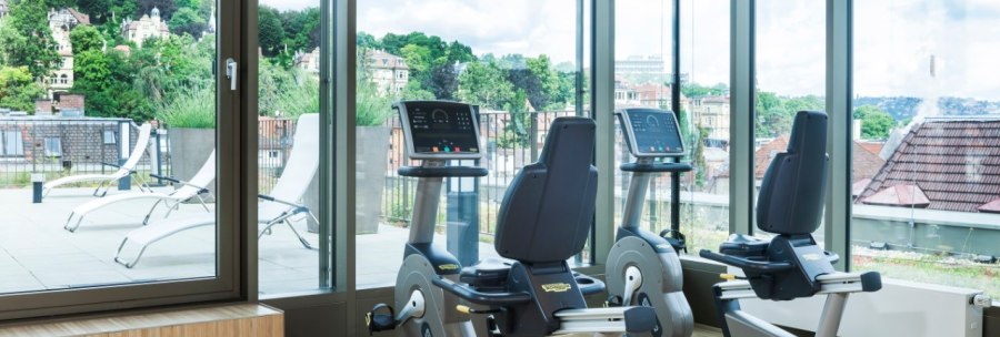 Fitness room with two bicycle ergometers, large windows and a view of a terrace with sun loungers and green landscape., © Park Inn by Radisson Stuttgart Fitness room with two bicycle ergometers, large windows and a view of a terrace with sun loungers and green landscape., © Park Inn by Radisson Stuttgart