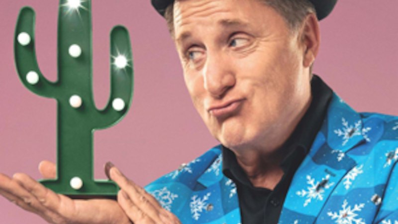 Person in blauem Anzug mit Schneeflockenmuster hält einen leuchtenden Kaktus vor rosa Hintergrund und macht eine lustige Grimasse., © Renitenztheater Stuttgart e.V. Person in blauem Anzug mit Schneeflockenmuster hält einen leuchtenden Kaktus vor rosa Hintergrund und macht eine lustige Grimasse., © Renitenztheater Stuttgart e.V.