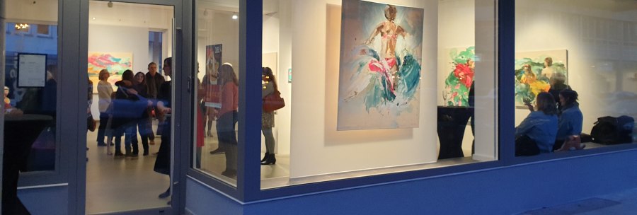 Eine Galerie mit gro&szlig;en Fenstern zeigt bunte Gem&auml;lde. Menschen stehen und betrachten die Kunstwerke im Inneren., &copy; EXOgallery Contemporary and New Media Art