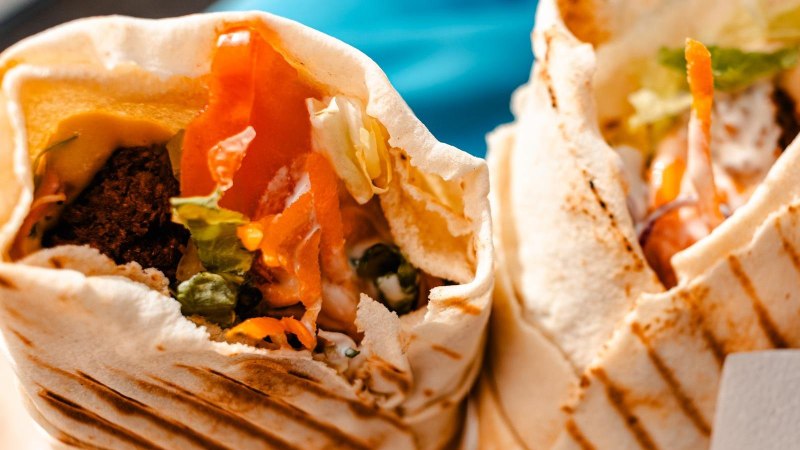 Two filled wraps with vegetables and falafel, appetizingly arranged. Close-up shows fresh ingredients and grilled bread., &copy; Stuttgart Marketing GmbH, Sarah Schmid