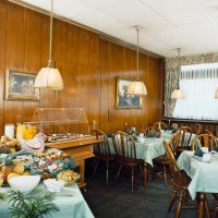 Frühstücksraum mit gedeckten Tischen, Holzstühlen und einem Buffet mit Brötchen, Obst und Saft. Holzwände und hängende Lampen schaffen eine gemütliche Atmosphäre., © Hotel Find Frühstücksraum mit gedeckten Tischen, Holzstühlen und einem Buffet mit Brötchen, Obst und Saft. Holzwände und hängende Lampen schaffen eine gemütliche Atmosphäre., © Hotel Find