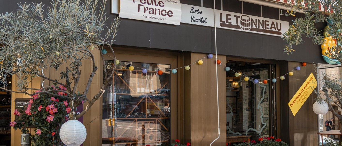 Bistro 'Petite France' und 'Le Tonneau' mit rot-weiß gestreifter Markise, bunten Lichtern und Pflanzen dekoriert. Einladende Atmosphäre., © SMG, Sarah Schmid