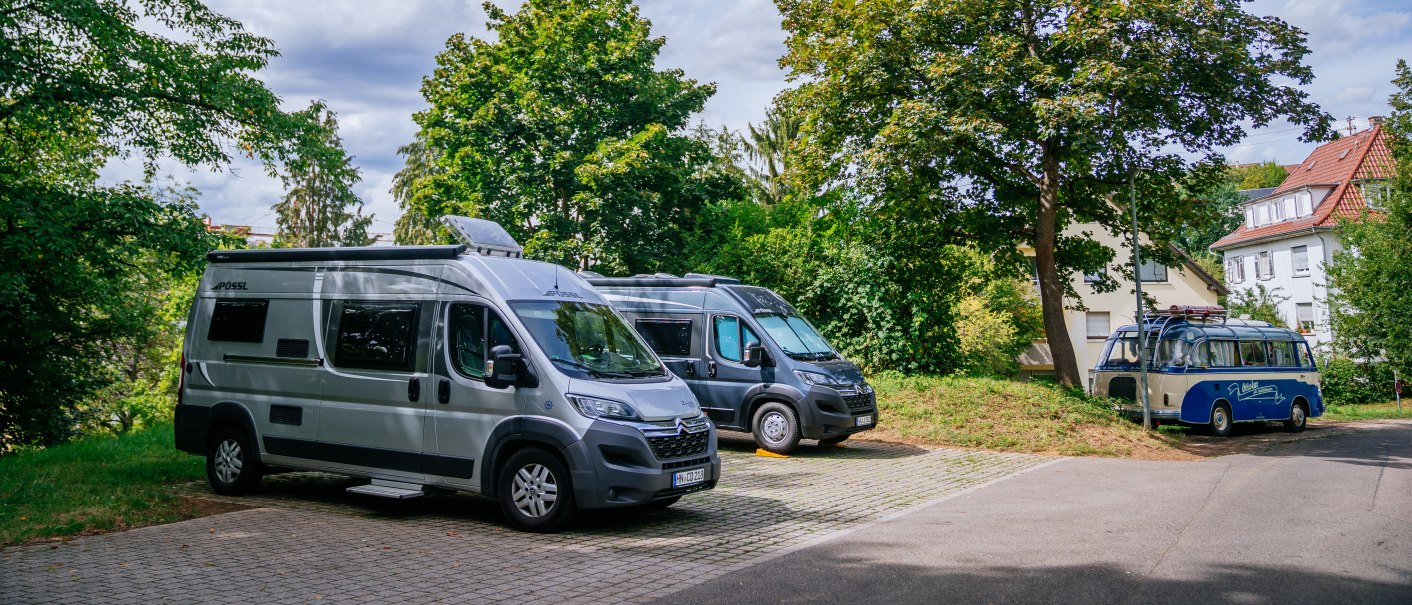Wohnmobilstellplatz mit mehreren geparkten Wohnmobilen, umgeben von Bäumen und einem Haus im Hintergrund., © Stuttgart-Marketing GmbH, Thomas Niedermüller Wohnmobilstellplatz mit mehreren geparkten Wohnmobilen, umgeben von Bäumen und einem Haus im Hintergrund., © Stuttgart-Marketing GmbH, Thomas Niedermüller