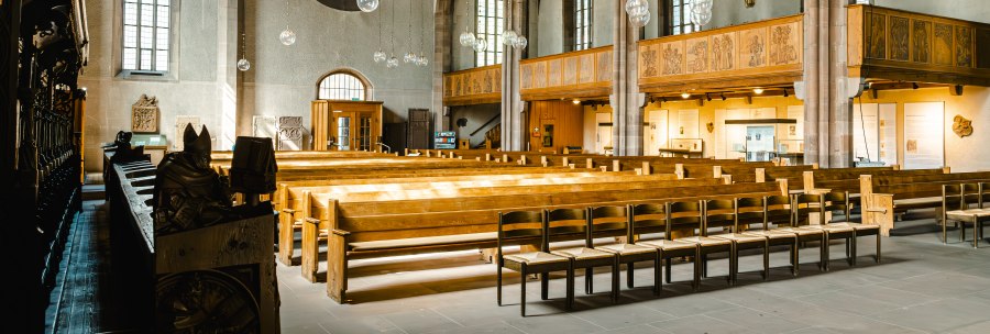 Innenansicht der Leonardskirche mit Holzb&auml;nken, Buntglasfenstern und h&ouml;lzernen Deckenbalken. Die Architektur ist gotisch gepr&auml;gt., &copy; SMG Stuttgart Marketing GmbH - Sarah Schmid