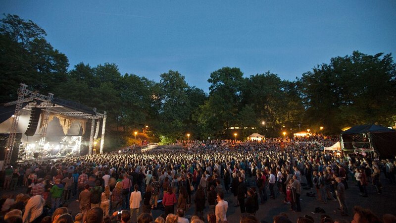 Open-air concert at dusk, large crowd in front of an illuminated stage surrounded by trees., &copy; W&uuml;rttembergische Staatstheater Stuttgart