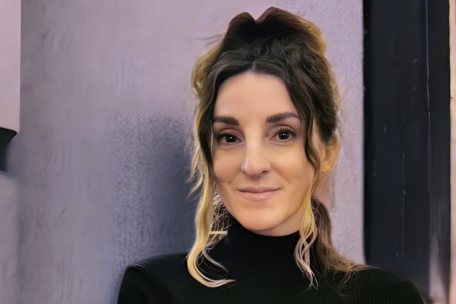 Porträt einer Frau mit hochgestecktem Haar und dunklem Oberteil vor neutralem Hintergrund., © Andrea A. Walter