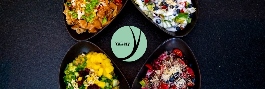 Four bowls with colorful salads and ingredients, including pasta, fruit and vegetables, on a black background. Yucery" logo in the center., &copy; Yuicery