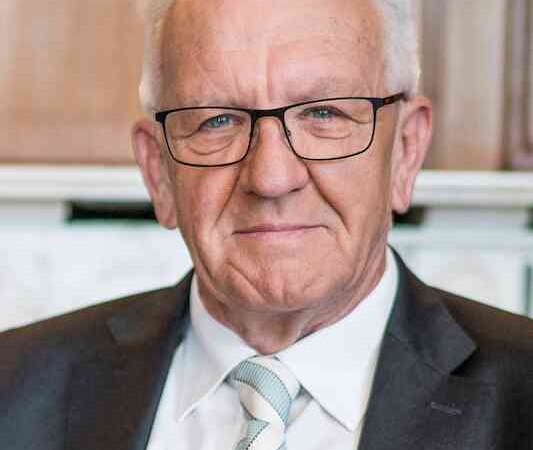 Ein älterer Mann mit Brille und grauem Haar trägt einen Anzug mit gestreifter Krawatte. Er sitzt vor einem Holzhintergrund., © Börsenverein des Deutschen Buchhandels, Landesverband Baden-Württemberg e.V.