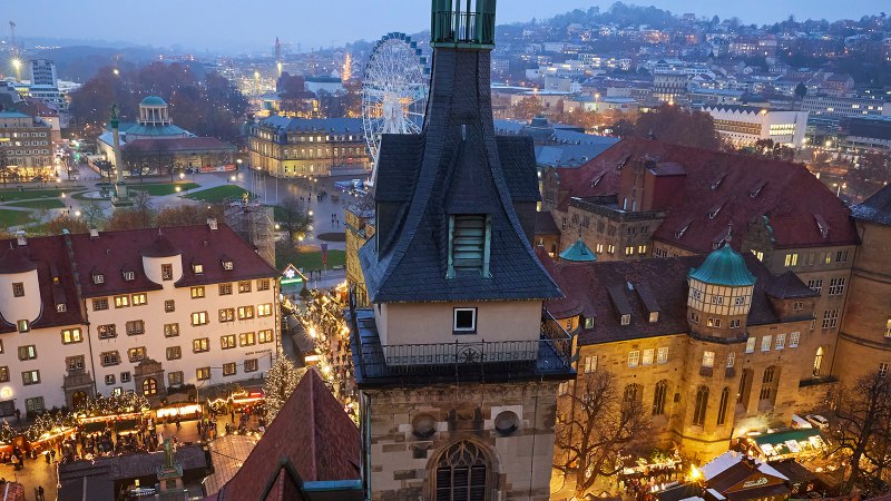 Blick auf den Schillerplatz und das Alte Schloss in Stuttgart bei Dämmerung. Der Weihnachtsmarkt ist beleuchtet, im Hintergrund ein Riesenrad., © Stuttgart Marketing GmbH