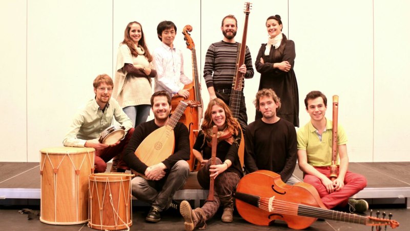 Neun Musiker des Ensembles La Gallarda posieren mit historischen Instrumenten wie Laute, Fl&ouml;te und Trommel auf einer B&uuml;hne., &copy; Ensemble La Gallarda