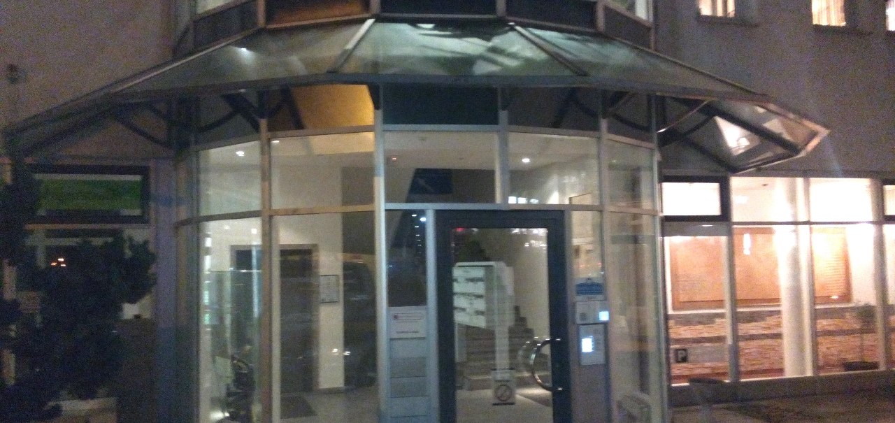 Moderner Geb&auml;udeeingang mit Glasfront, beleuchtet bei Nacht. Innen sind Pflanzen sichtbar. Der Eingang hat eine Glast&uuml;r und ein Vordach., &copy; Central Hotel