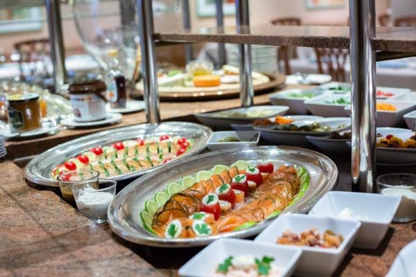 Breakfast buffet with salmon, tomatoes, cucumbers and side dishes on a table., © Kronen Hotel GmbH