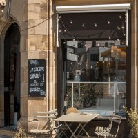 Caf&eacute; with outdoor seating, graffiti on the wall, fairy lights above the entrance. Sign with "Coffee & cake". City street in the background., &copy; SMG Stuttgart Marketing GmbH - Sarah Schmid