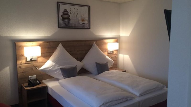 Cozy double room with wooden headboard, two pillows, two bedside tables and a picture on the wall., © Hotel Lamm Hegnach Cozy double room with wooden headboard, two pillows, two bedside tables and a picture on the wall., © Hotel Lamm Hegnach