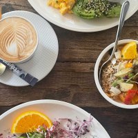 Ein reich gedeckter Fr&uuml;hst&uuml;ckstisch mit Kaffee, Pancakes mit Speck, Avocado mit R&uuml;hrei und einer Schale mit frischem Obst., &copy; SMG