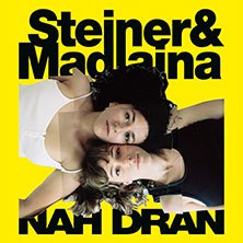 Zwei Frauen liegen Kopf an Kopf auf einem gelben Hintergrund. Der Text 'Steiner & Madlaina - Nah Dran' ist in Schwarz darübergelegt., © links im Bild Zwei Frauen liegen Kopf an Kopf auf einem gelben Hintergrund. Der Text 'Steiner & Madlaina - Nah Dran' ist in Schwarz darübergelegt., © links im Bild