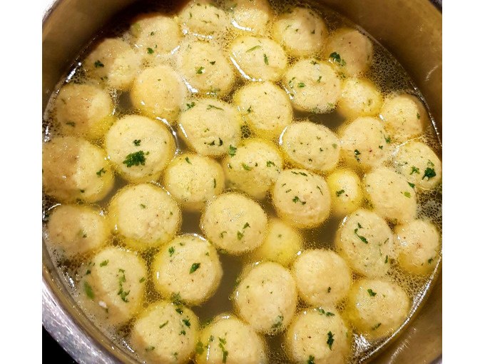A pot with several bread dumplings floating in a clear broth. The dumplings are sprinkled with herbs., © Kultweine-Kochwelten-Kunstücke - Kochschule Sonja Lenz A pot with several bread dumplings floating in a clear broth. The dumplings are sprinkled with herbs., © Kultweine-Kochwelten-Kunstücke - Kochschule Sonja Lenz