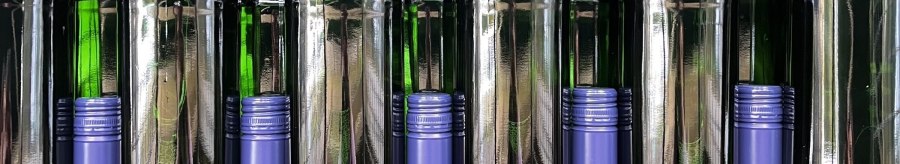 Stacked green wine bottles with blue caps on a shelf. The bottles reflect the light, creating a symmetrical pattern., © Weinhof Zaiß Stacked green wine bottles with blue caps on a shelf. The bottles reflect the light, creating a symmetrical pattern., © Weinhof Zaiß