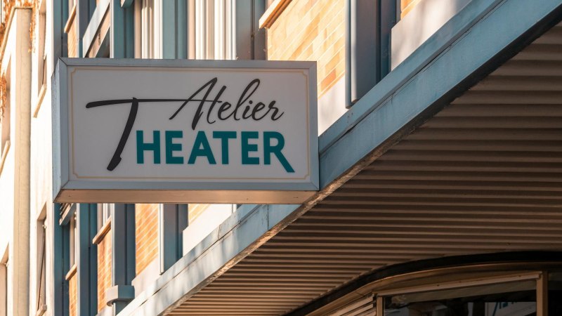 A sign with the words 'Atelier Theater' hangs on a building. The façade is modern and the weather is sunny., © SMG Stuttgart Marketing GmbH - Sarah Schmid A sign with the words 'Atelier Theater' hangs on a building. The façade is modern and the weather is sunny., © SMG Stuttgart Marketing GmbH - Sarah Schmid