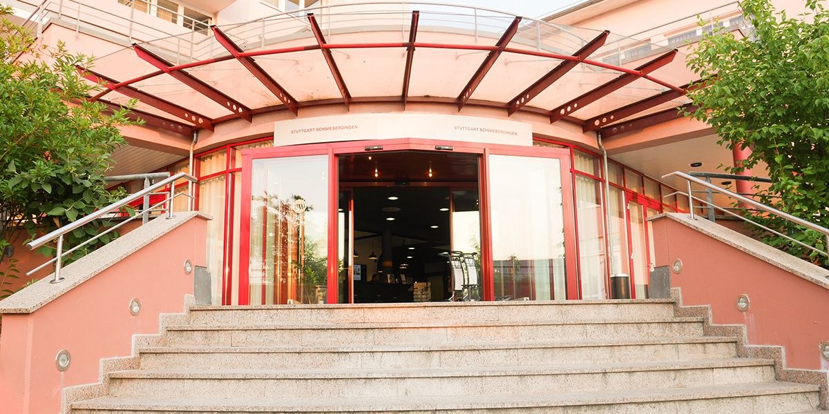 Entrance to the Best Western loftstyle hotel in Schwieberdingen with glass roofing and red accents., © Best Western loftstyle hotel Schwieberdingen