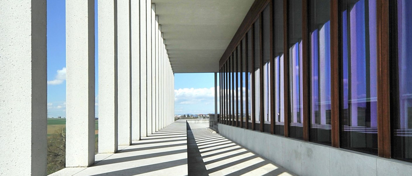 Langer Gang mit Säulen und Glasfenstern im Literaturmuseum der Moderne in Marbach. Die Architektur erzeugt ein Spiel aus Licht und Schatten., © DLA Marbach (Chris Korner) Langer Gang mit Säulen und Glasfenstern im Literaturmuseum der Moderne in Marbach. Die Architektur erzeugt ein Spiel aus Licht und Schatten., © DLA Marbach (Chris Korner)