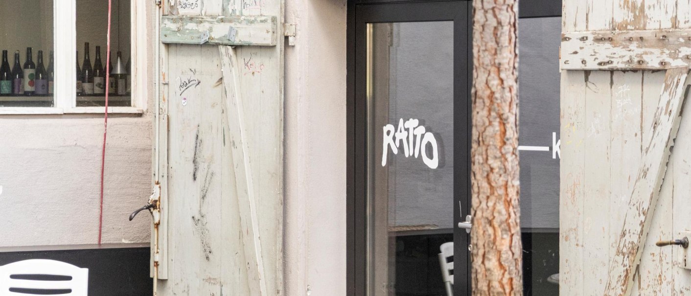 Entrance to the Ratto Bar with glass front and old, weathered wooden doors. Wine bottles can be seen in the window., &copy; Stuttgart-Marketing GmbH, Sarah Schmid