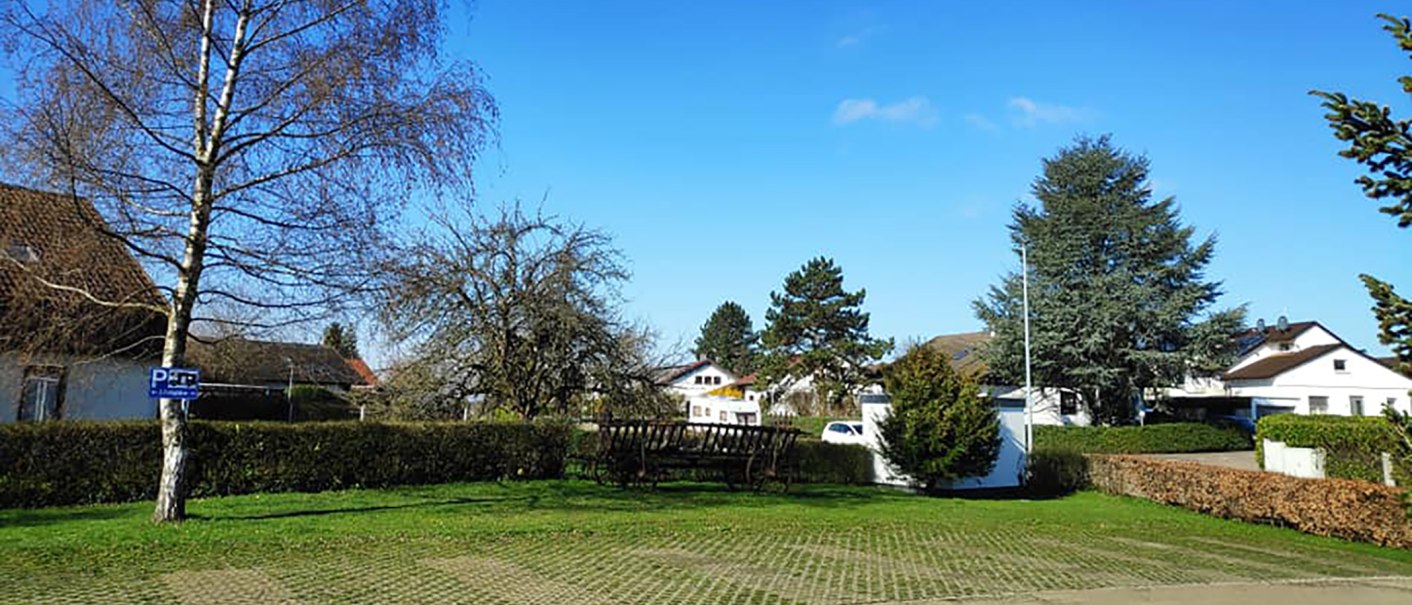 Ein Wohnmobilstellplatz mit Bäumen und einem Parkplatzschild. Im Hintergrund sind Häuser und ein blauer Himmel zu sehen., © Dieter Schurr, Gasthaus Hirsch Ein Wohnmobilstellplatz mit Bäumen und einem Parkplatzschild. Im Hintergrund sind Häuser und ein blauer Himmel zu sehen., © Dieter Schurr, Gasthaus Hirsch