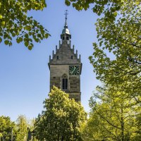 A church tower rises above green trees under a clear blue sky. The scene exudes a sense of peace and a connection to nature., &copy; SMG Stuttgart Marketing GmbH - Sarah Schmid