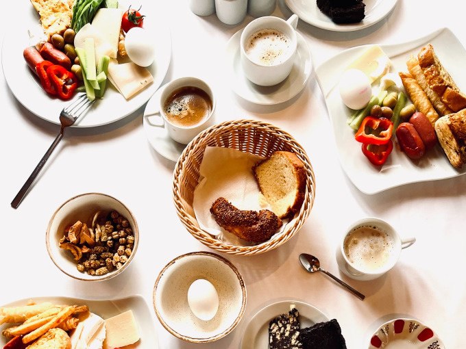 Ein reich gedeckter Tisch mit Brot, Eiern, Gemüse, Kaffee und Gebäck, ideal für einen gemütlichen Winterbrunch., © Cool-Tours StattReisen Ein reich gedeckter Tisch mit Brot, Eiern, Gemüse, Kaffee und Gebäck, ideal für einen gemütlichen Winterbrunch., © Cool-Tours StattReisen