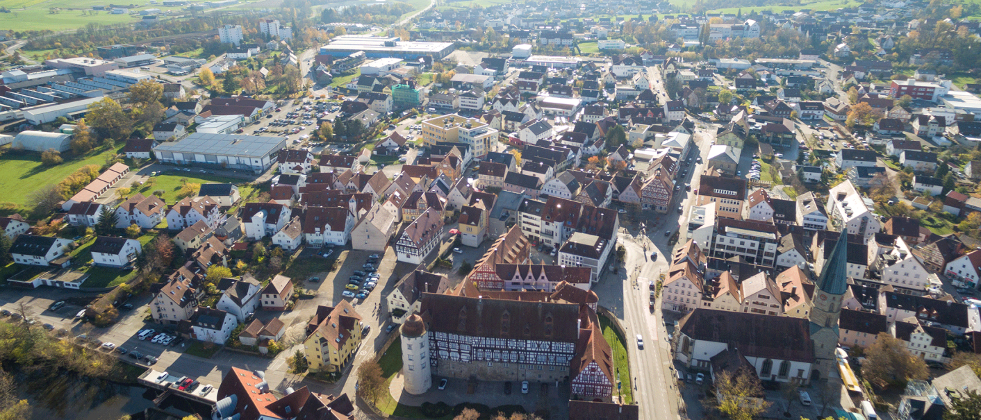 Aerial view of Gaildorf with half-timbered houses, church and surrounding buildings. The town is surrounded by green fields., © Stadt Gaildorf