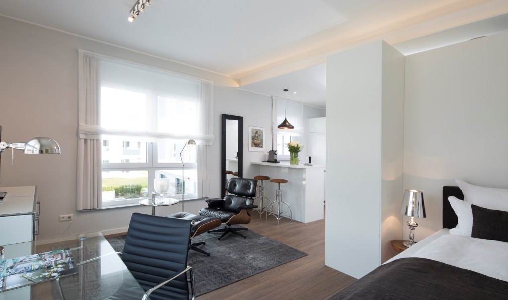 Modern suite with a bed, desk, armchair and a small kitchenette. Bright furnishings with large windows and stylish furniture., © Hotel LOGIS Modern suite with a bed, desk, armchair and a small kitchenette. Bright furnishings with large windows and stylish furniture., © Hotel LOGIS