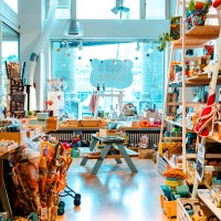 Bunter Spielzeugladen mit Regalen voller Spielsachen, Büchern und Accessoires. Ein Tisch steht in der Mitte, das Schild "Pippi & Annika" im Hintergrund., © SMG_Sarah Schmid Bunter Spielzeugladen mit Regalen voller Spielsachen, Büchern und Accessoires. Ein Tisch steht in der Mitte, das Schild "Pippi & Annika" im Hintergrund., © SMG_Sarah Schmid