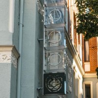 Facade of a building with decorated elements and a sign with logo. A tree casts shadows on the wall. Clear, sunny atmosphere., &copy; SMG Stuttgart Marketing GmbH - Sarah Schmid