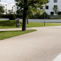 Ein gepflegter Park mit geschwungenen Gehwegen, B&auml;umen und modernen Wohngeb&auml;uden im Hintergrund. Ein Gedenkstein ist sichtbar., &copy; Foto-Kunst Andreas Keller