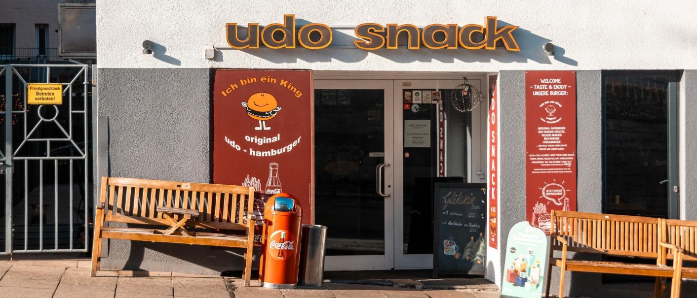 Entrance to the snack bar 'udo snack' with two wooden benches and a garbage can in front of it., &copy; SMG Stuttgart Marketing GmbH - Sarah Schmid