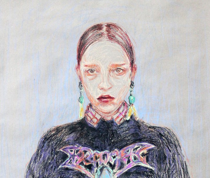 Ein ausdrucksstarkes Portr&auml;t einer Frau mit ernster Miene, bunten Ohrringen und einem dunklen Oberteil mit auff&auml;lligem Schriftzug., &copy; W&uuml;rttembergische Staatstheater Stuttgart