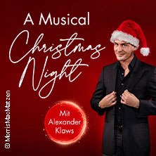 Ein Mann in schwarzem Anzug mit Weihnachtsmütze vor rotem Hintergrund. Text: 'A Musical Christmas Night' und 'Mit Alexander Klaws'., © links im Bild
