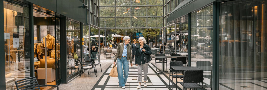 Two people stroll through the Calwer Passage with its stores and caf&eacute;s. The arcade has a glass roof and a modern design., &copy; Stuttgart-Marketing GmbH, Sarah Schmid