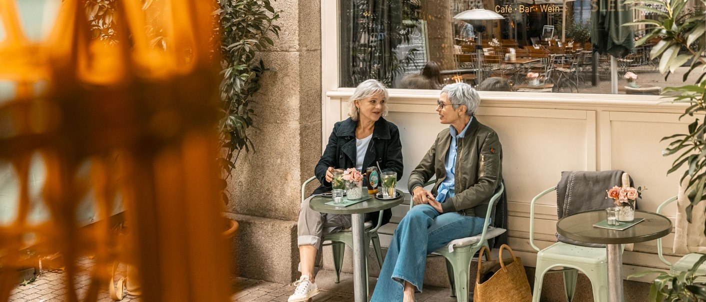 Zwei Frauen sitzen vor Walthers Café Bar an einem Tisch und unterhalten sich. Im Hintergrund ist das Café zu sehen., © Stuttgart Marketing GmbH - Sarah Schmid