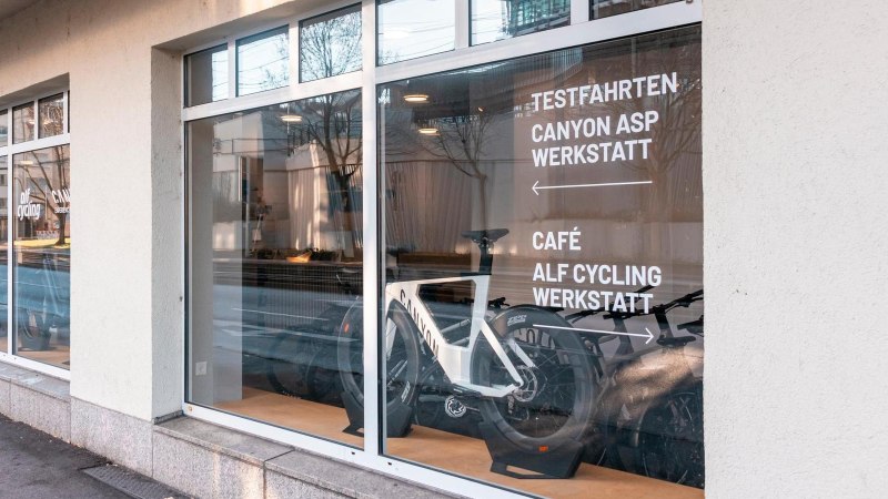 Ein Fahrradgesch&auml;ft mit gro&szlig;en Fenstern zeigt Fahrr&auml;der im Schaufenster. Auf der Scheibe steht 'Testfahrten, Canyon ASP Werkstatt, Caf&eacute;, Alf Cycling Werkstatt'., &copy; Stuttgart-Marketing GmbH, Sarah Schmid