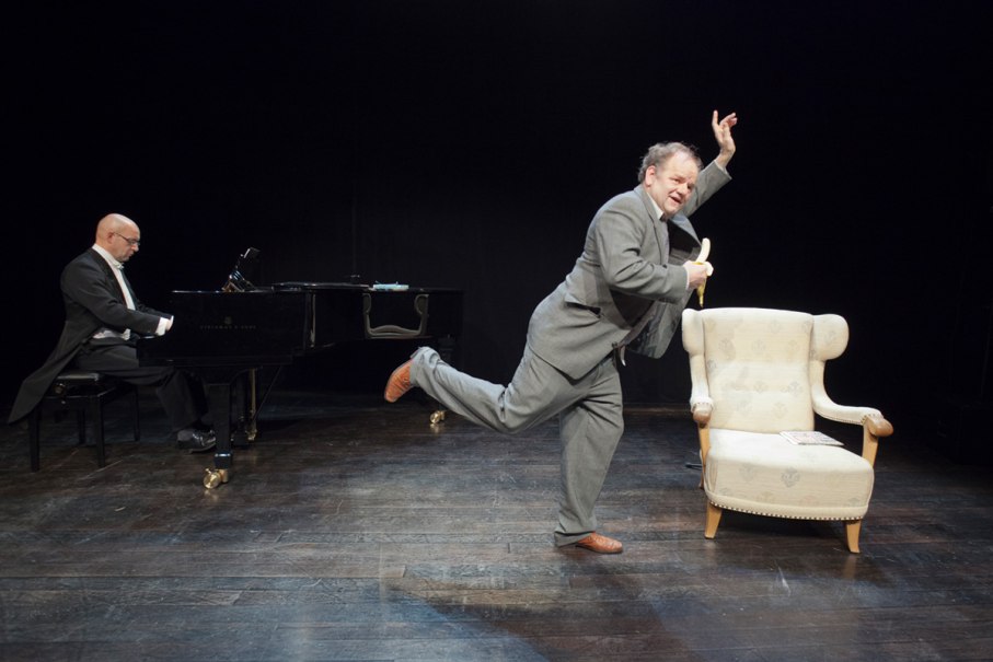 Ein Pianist am Flügel und ein Mann in Anzug mit Banane auf der Bühne. Ein Sessel steht daneben., © Foto: Bernhard Fuchs, CH-8135 Langnau am Albis