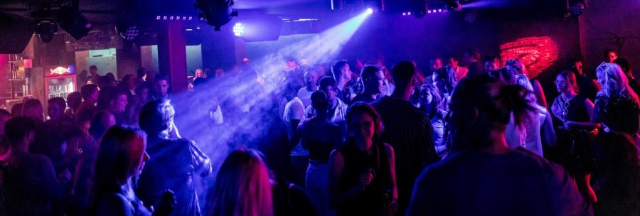 A lively nightclub with dancing people, colorful lights and fog effects. The atmosphere is lively and full of energy., © BOA Stuttgart