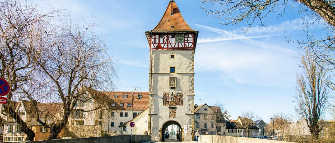 The Beinsteiner Gate in Waiblingen, a historic city gate featuring half-timbered architecture and a clock, surrounded by trees and a blue sky., © SMG Stuttgart Marketing GmbH - Sarah Schmid The Beinsteiner Gate in Waiblingen, a historic city gate featuring half-timbered architecture and a clock, surrounded by trees and a blue sky., © SMG Stuttgart Marketing GmbH - Sarah Schmid
