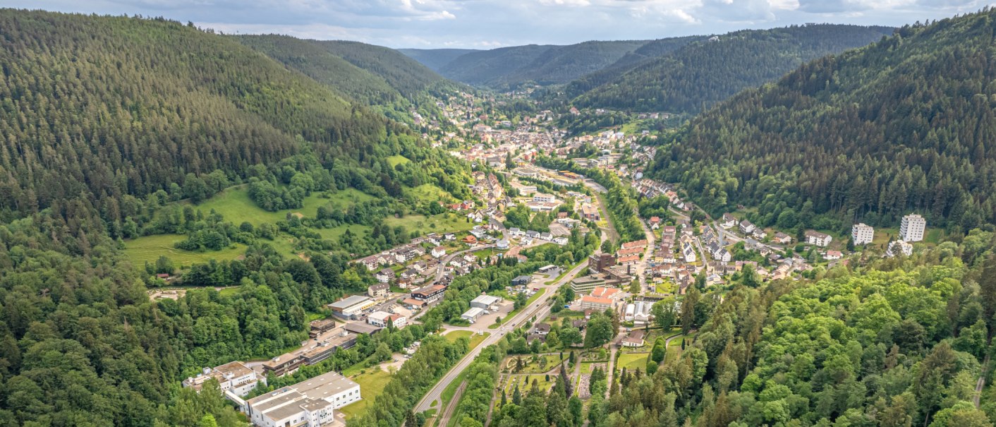 Aerial view of Bad Wildbad in the Black Forest, nestled in a narrow, wooded valley with roads, houses, and green slopes., &copy; Lightworkart, Touristik Bad Wildbad GmbH