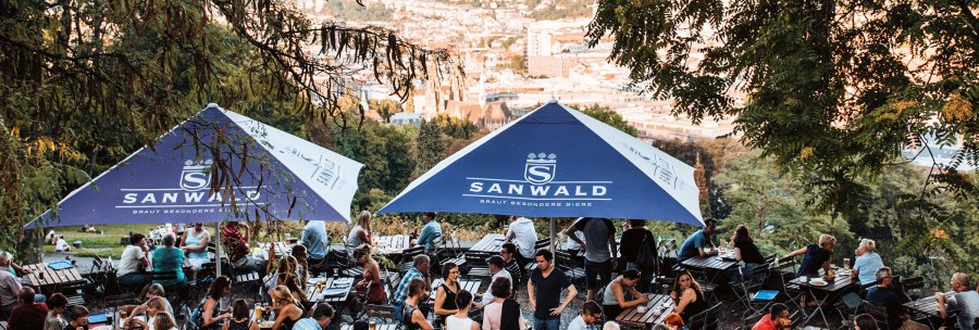 Beer garden on the Karlsh&ouml;he in Stuttgart with many people under blue parasols, the city view in the background., &copy; Romeo Felsenreich, sommertage.com