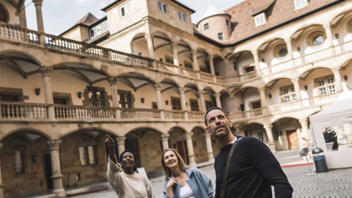 Three people stand in the inner courtyard of the W&uuml;rttemberg State Museum and look upwards. The inner courtyard is surrounded by arcades and historic buildings., &copy; Stuttgart-Marketing GmbH, wpsteinheisser