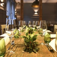 A stylishly laid dining table with wine glasses, green glasses and plants as decoration in an elegant room., © Classic Rock Café Gastronomie- Betriebs GmbH A stylishly laid dining table with wine glasses, green glasses and plants as decoration in an elegant room., © Classic Rock Café Gastronomie- Betriebs GmbH