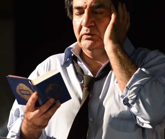 Ein Mann in Hemd und Krawatte liest nachdenklich aus einem kleinen Buch vor, die Hand an der Wange., &copy; Theaterhaus Stuttgart e.V.