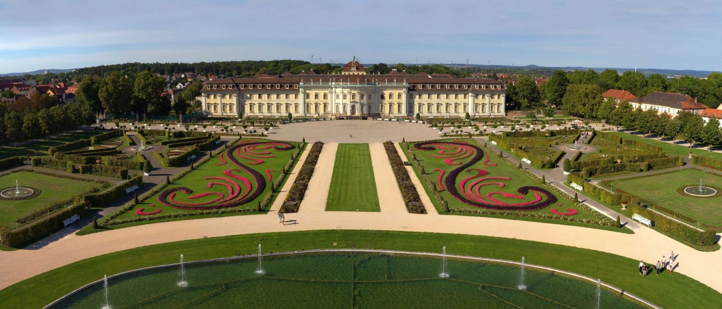 Aerial view of Ludwigsburg Residential Palace, surrounded by symmetrical gardens and fountains, with green lawns and flowering beds., © Tourismus & Events Ludwigsburg