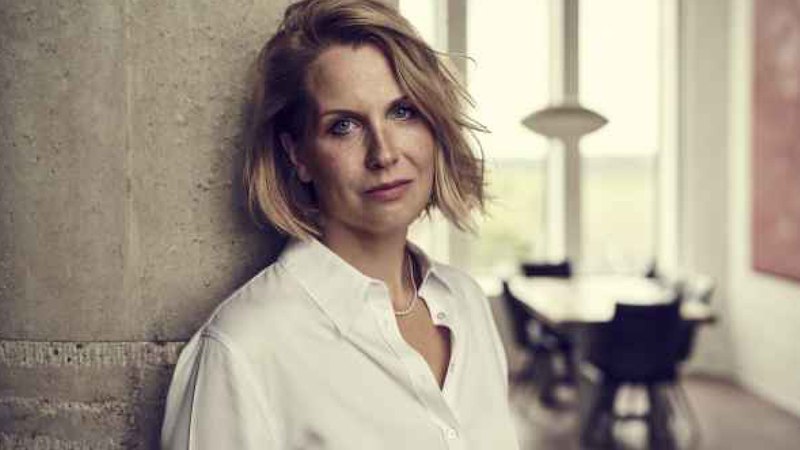 Frau in weißem Hemd lehnt an einer Betonwand, im Hintergrund ein Tisch mit Stühlen und große Fenster., © Internationale Hugo-Wolf-Akademie Frau in weißem Hemd lehnt an einer Betonwand, im Hintergrund ein Tisch mit Stühlen und große Fenster., © Internationale Hugo-Wolf-Akademie